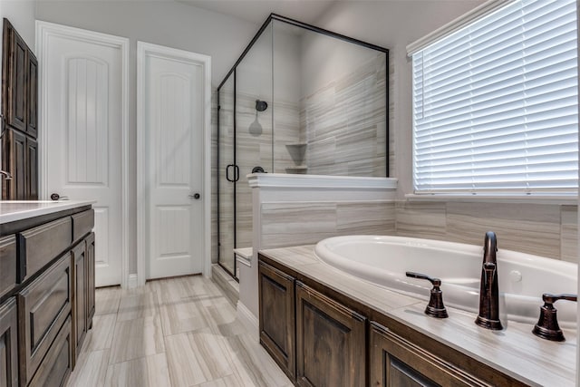 bathroom featuring independent shower and bath and vanity