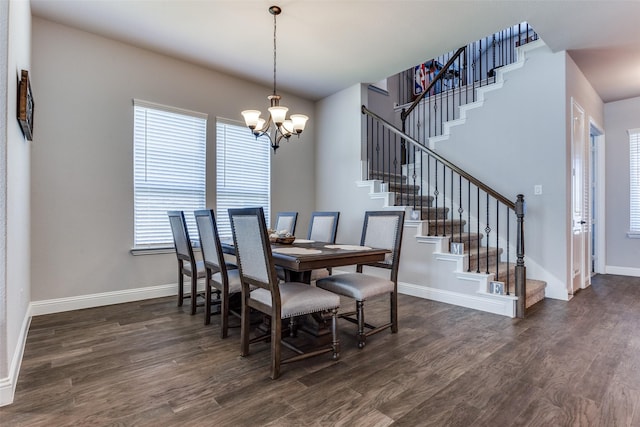 dining room with dark hardwood / wood-style flooring and a chandelier