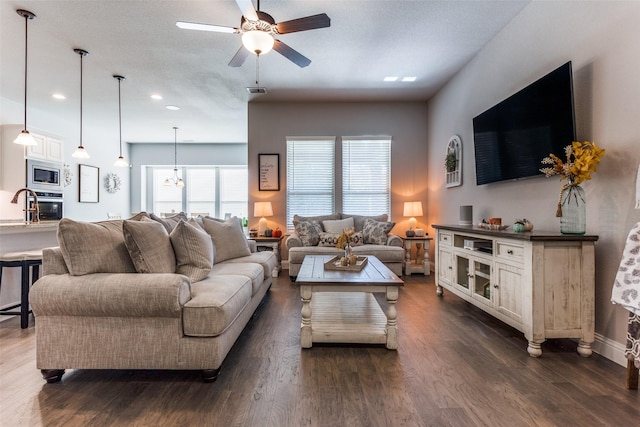 living room featuring ceiling fan and dark hardwood / wood-style flooring