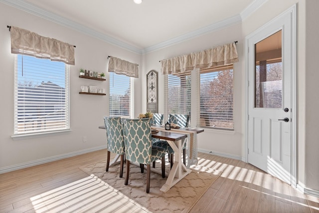 dining space featuring light hardwood / wood-style flooring and crown molding