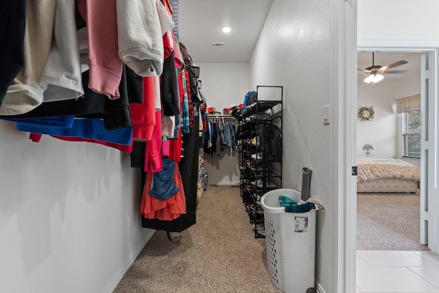 walk in closet with ceiling fan and light carpet