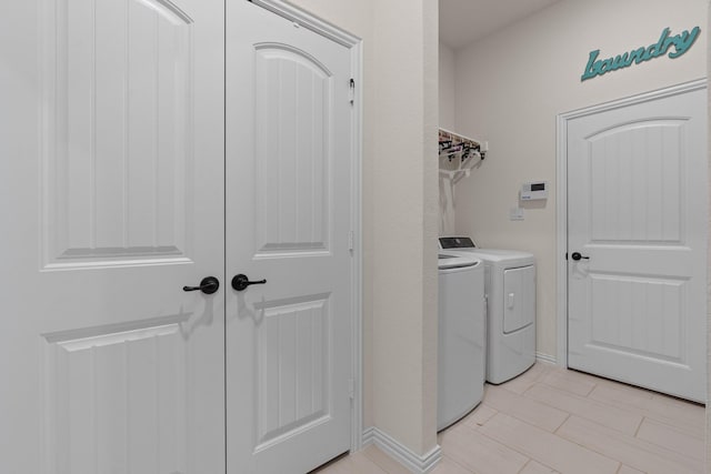 laundry room with washing machine and dryer and light tile patterned floors