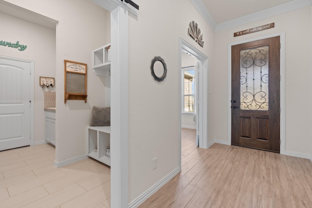 entryway with light hardwood / wood-style flooring, crown molding, and a barn door