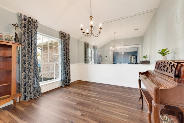 interior space with an inviting chandelier, hardwood / wood-style floors, lofted ceiling, and a healthy amount of sunlight