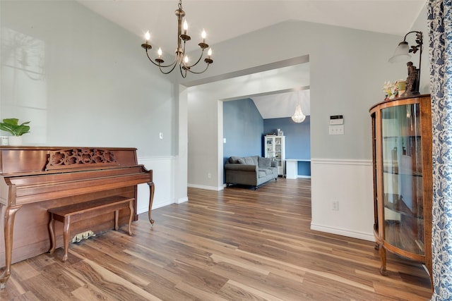 misc room featuring hardwood / wood-style flooring, lofted ceiling, and a notable chandelier