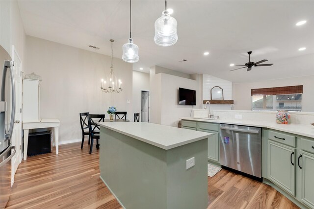 kitchen with green cabinetry, stainless steel fridge, hanging light fixtures, and a kitchen island