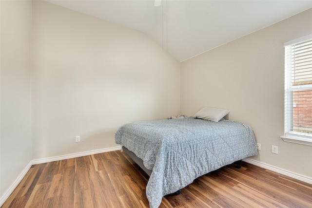 bedroom featuring wood-type flooring and vaulted ceiling