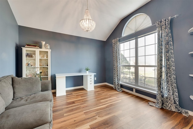 living area featuring lofted ceiling, light hardwood / wood-style flooring, and a notable chandelier