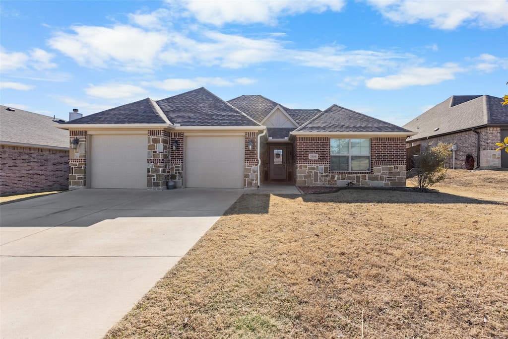 ranch-style house featuring a garage and a front yard