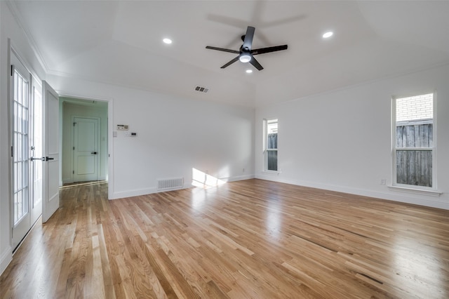 unfurnished room with ceiling fan, light hardwood / wood-style floors, and a tray ceiling