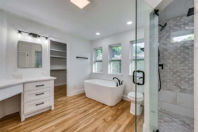 full bathroom featuring wood-type flooring, a healthy amount of sunlight, and independent shower and bath