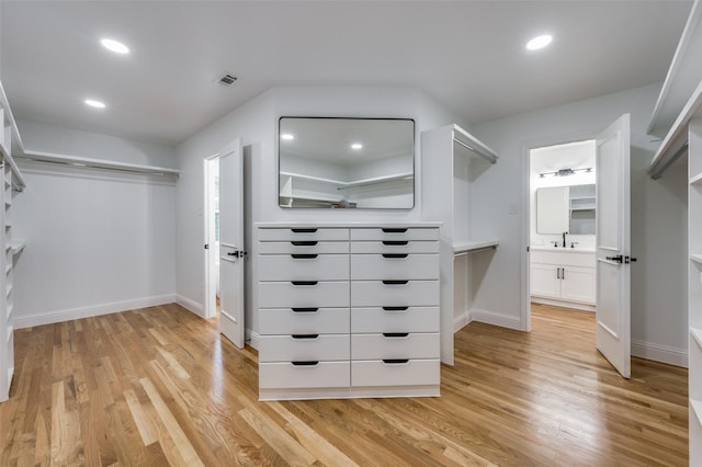 spacious closet featuring sink and light hardwood / wood-style floors