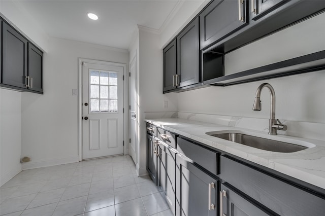 kitchen featuring light stone countertops, sink, light tile patterned flooring, ornamental molding, and gray cabinets