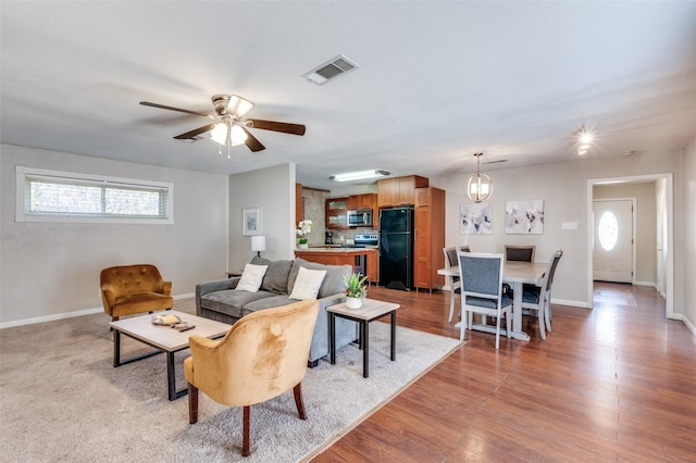 living room featuring ceiling fan and light hardwood / wood-style floors