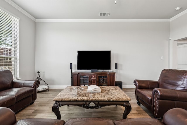 living room with light wood-type flooring, a wealth of natural light, and ornamental molding