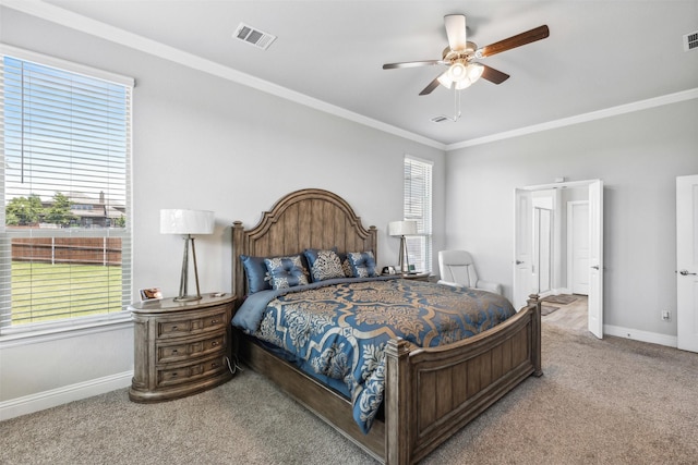 carpeted bedroom with ceiling fan and ornamental molding