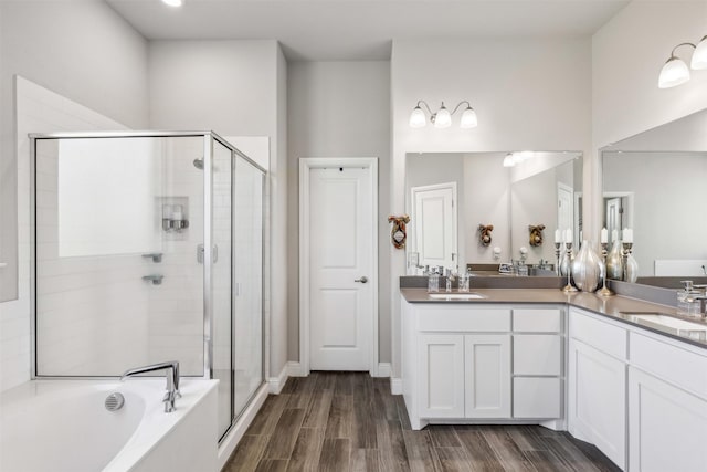 bathroom featuring vanity, wood-type flooring, and plus walk in shower