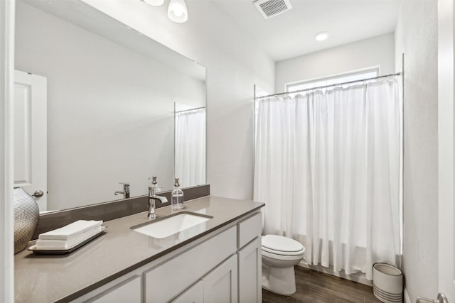 full bathroom with wood-type flooring, toilet, vanity, and shower / tub combo with curtain