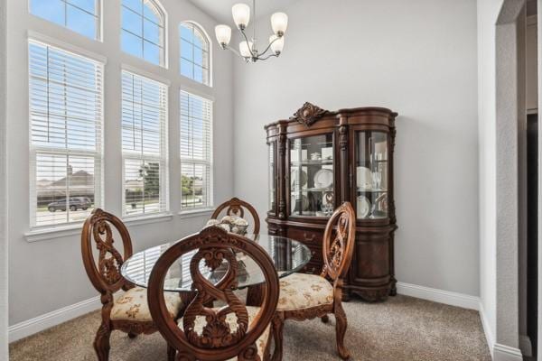 dining area with a chandelier and carpet flooring