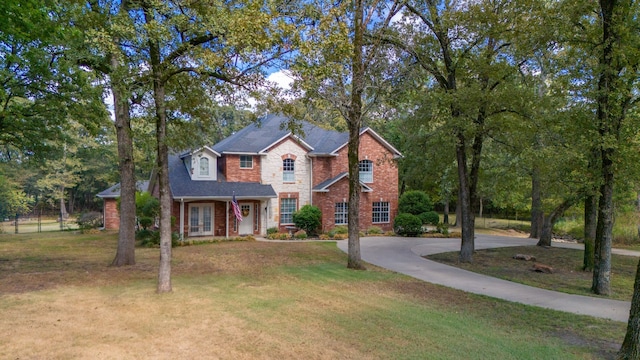 traditional home with a front yard, french doors, and brick siding