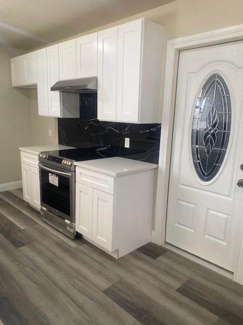 kitchen featuring backsplash, dark hardwood / wood-style flooring, and white cabinets