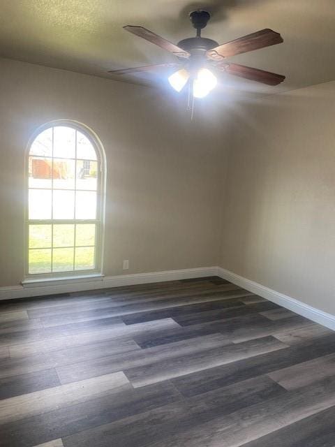 empty room with dark hardwood / wood-style floors and ceiling fan