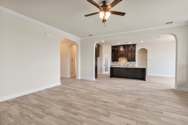 unfurnished living room featuring crown molding, light hardwood / wood-style flooring, and ceiling fan