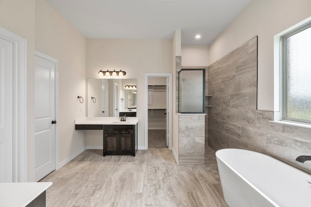 bathroom with vanity and shower with separate bathtub