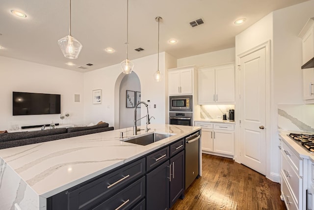 kitchen featuring decorative light fixtures, white cabinetry, stainless steel appliances, an island with sink, and sink