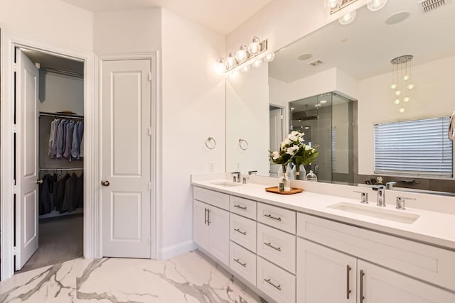 bathroom featuring a shower with door and vanity