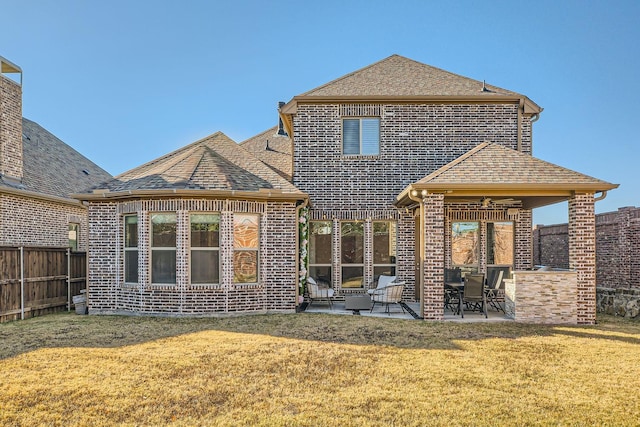 back of property with a patio area and a yard