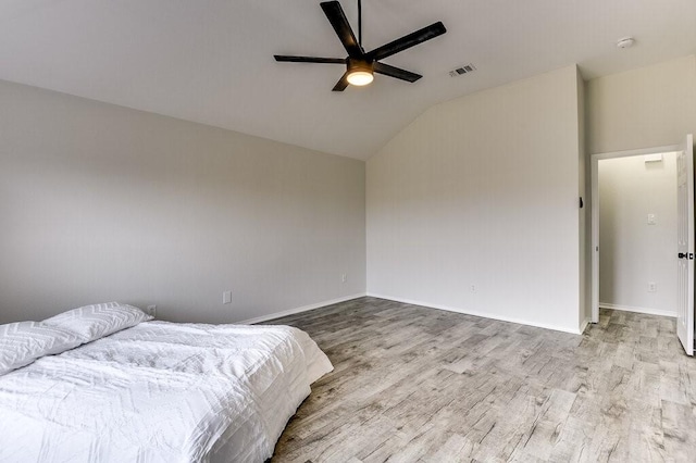 bedroom with ceiling fan, light hardwood / wood-style flooring, and vaulted ceiling