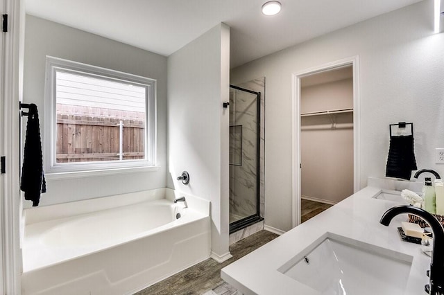 bathroom with hardwood / wood-style floors, vanity, and plus walk in shower