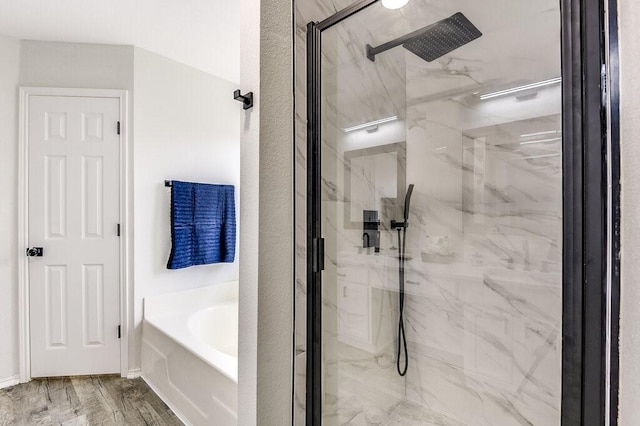 bathroom featuring wood-type flooring and shower with separate bathtub