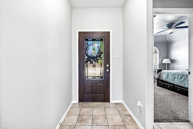 tiled entryway featuring ceiling fan and plenty of natural light