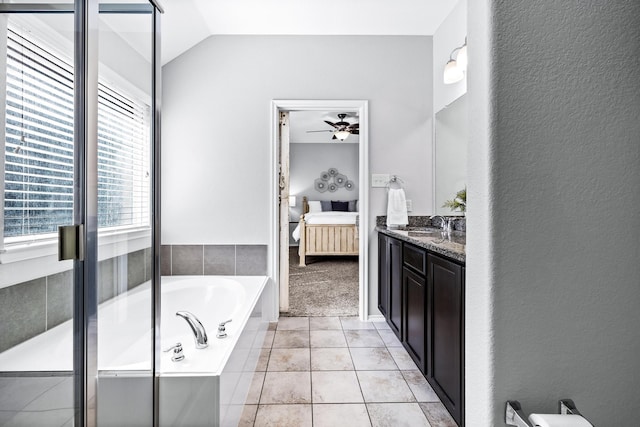 bathroom featuring lofted ceiling, tile patterned floors, shower with separate bathtub, vanity, and ceiling fan