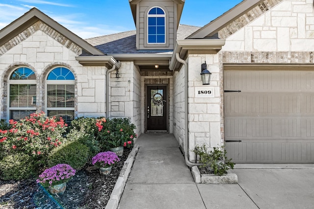 property entrance featuring a garage, stone siding, and a shingled roof