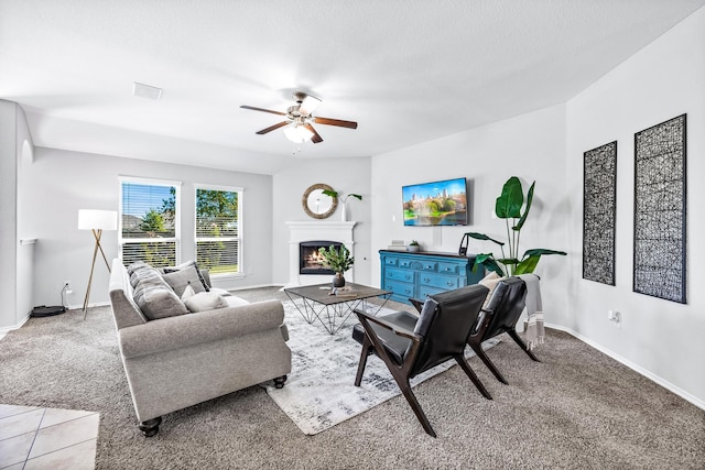 living room with a ceiling fan, carpet, a lit fireplace, and baseboards