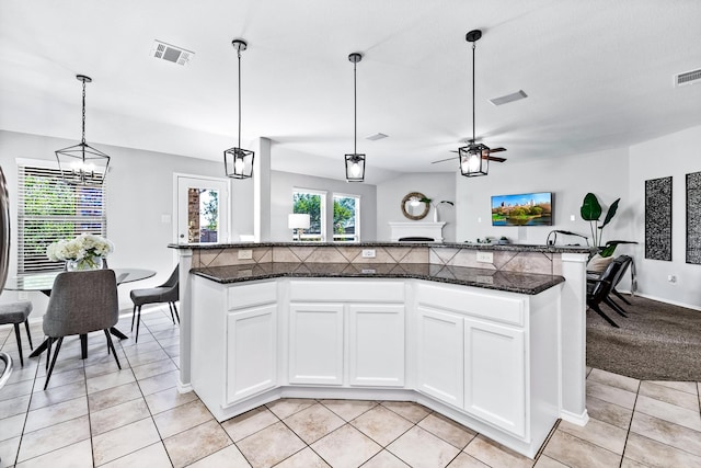 kitchen with pendant lighting, light tile patterned floors, visible vents, white cabinetry, and ceiling fan