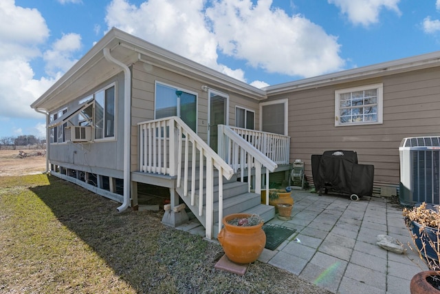 exterior space featuring a patio, cooling unit, and a yard