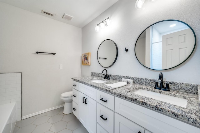 bathroom with toilet, vanity, and tile patterned flooring