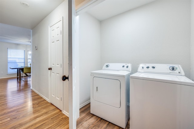 washroom with light wood-type flooring and separate washer and dryer