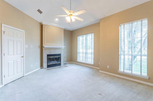 unfurnished living room with a fireplace, ceiling fan, and light carpet