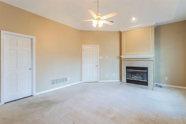 unfurnished living room featuring ceiling fan, light colored carpet, and a tiled fireplace