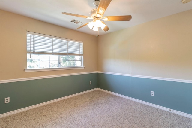 carpeted spare room featuring ceiling fan