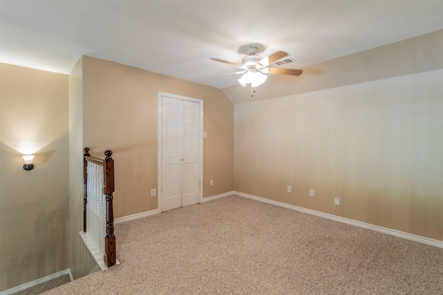 empty room with ceiling fan, carpet floors, and lofted ceiling