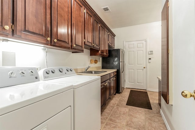 clothes washing area with cabinets, separate washer and dryer, and sink