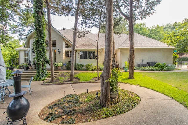 view of front of home featuring central AC and a front yard