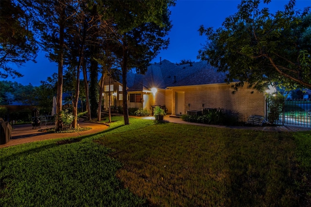 view of front of house with cooling unit and a lawn