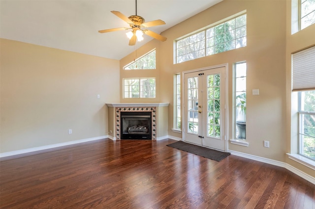 unfurnished living room featuring a fireplace, high vaulted ceiling, a wealth of natural light, and dark hardwood / wood-style flooring